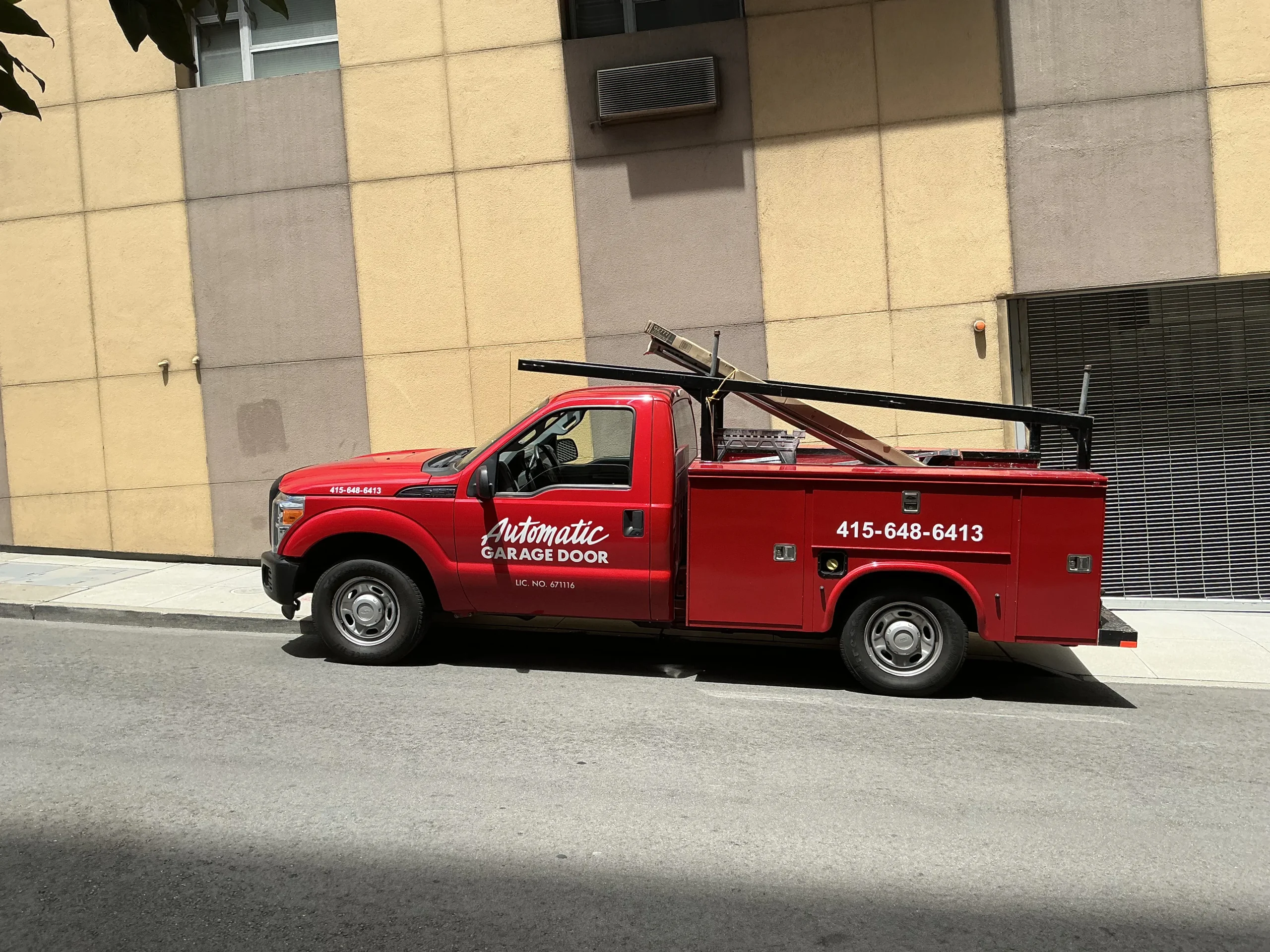 A red Automatic Garage Door service truck parked on a city street, providing Licensed Garage Door Services in San Francisco, CA.